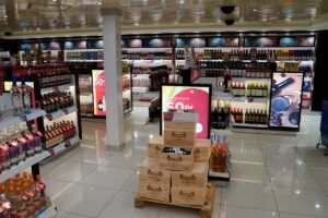 Bright white floor in a duty-free shop with various products, aincluding spirits