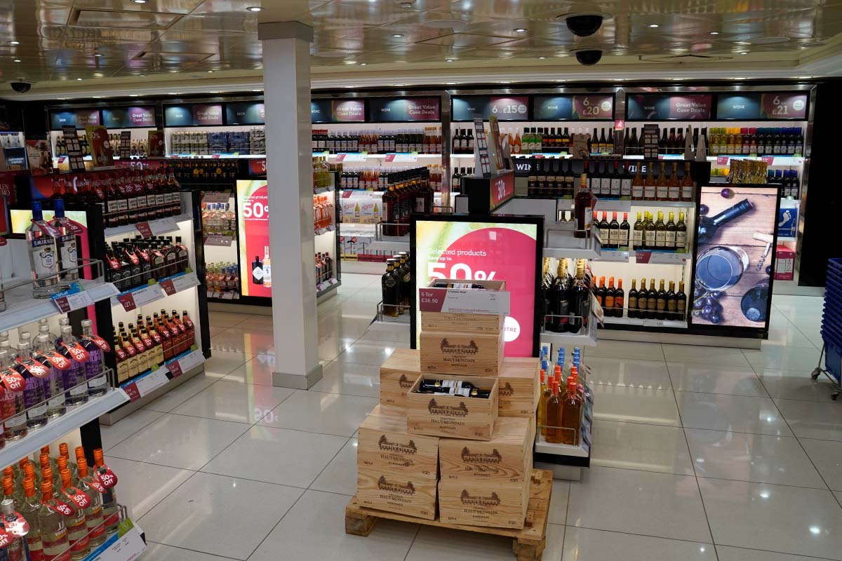 Bright white floor in a duty-free shop with various products, aincluding spirits